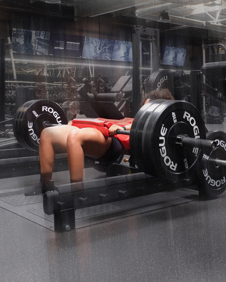 woman doing heavy hip thrusts using uppper barbell pad