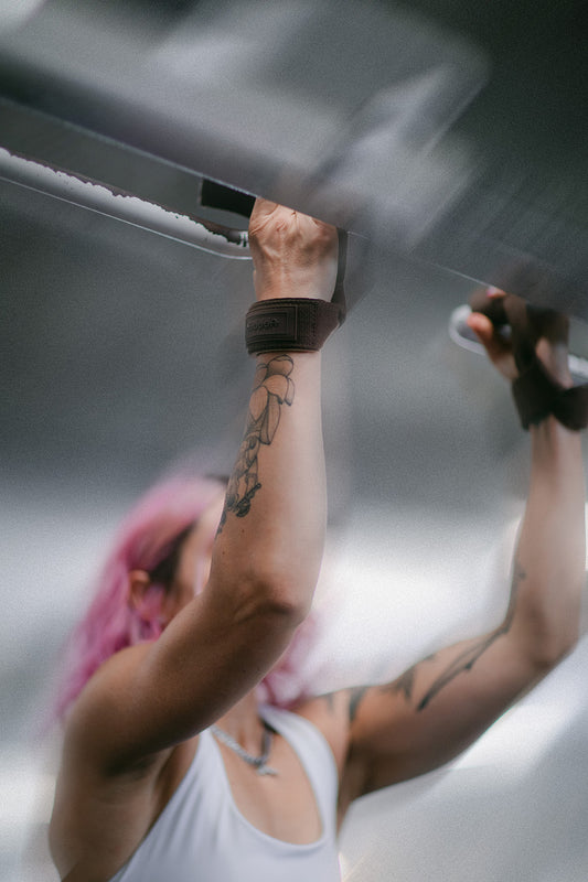 woman doing pull-ups with lifting straps