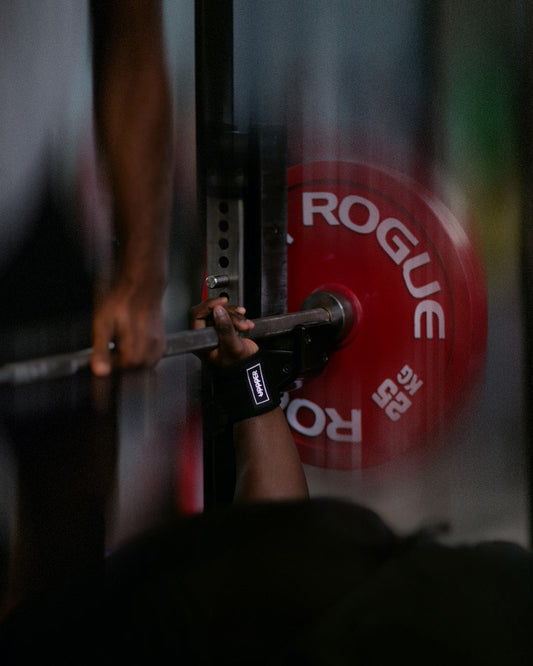 man doing heavy bench press with uppper wrist wraps