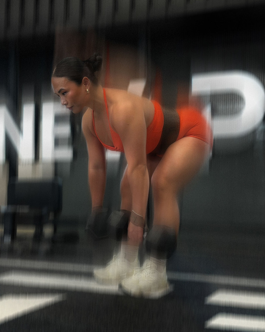 woman doing deadlift variations with uppper lifting straps