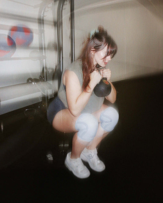 woman squatting with knee sleeves