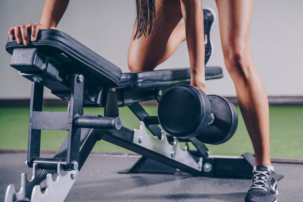 woman doing dumbbell rows, a compound exercise