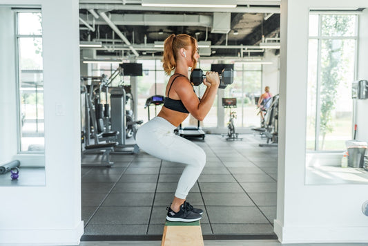 women doing a squat to shoulder press