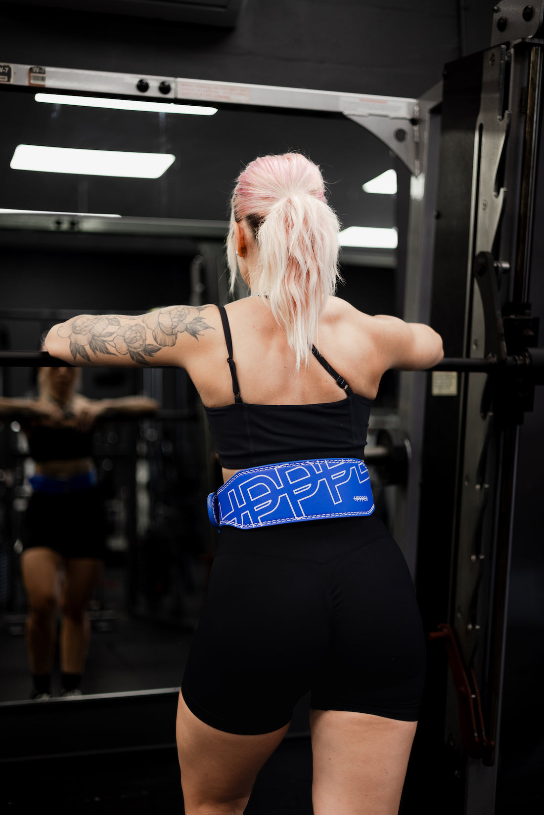 woman standing in front of smith machine