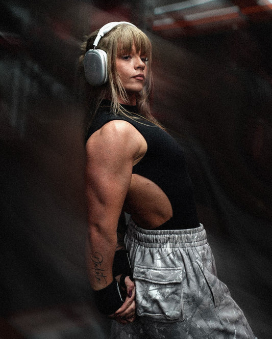 woman flexing triceps wearing uppper wrist wraps