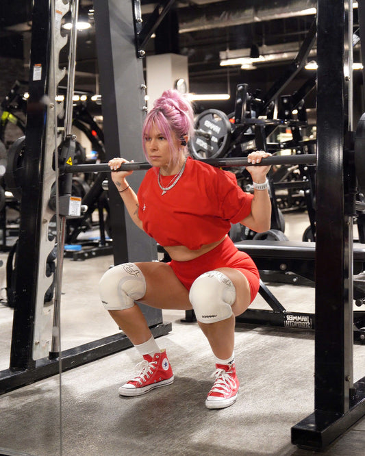 woman doing squats wearing uppper knee sleeves