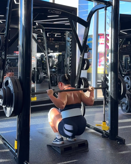 woman squatting using uppper lever belt