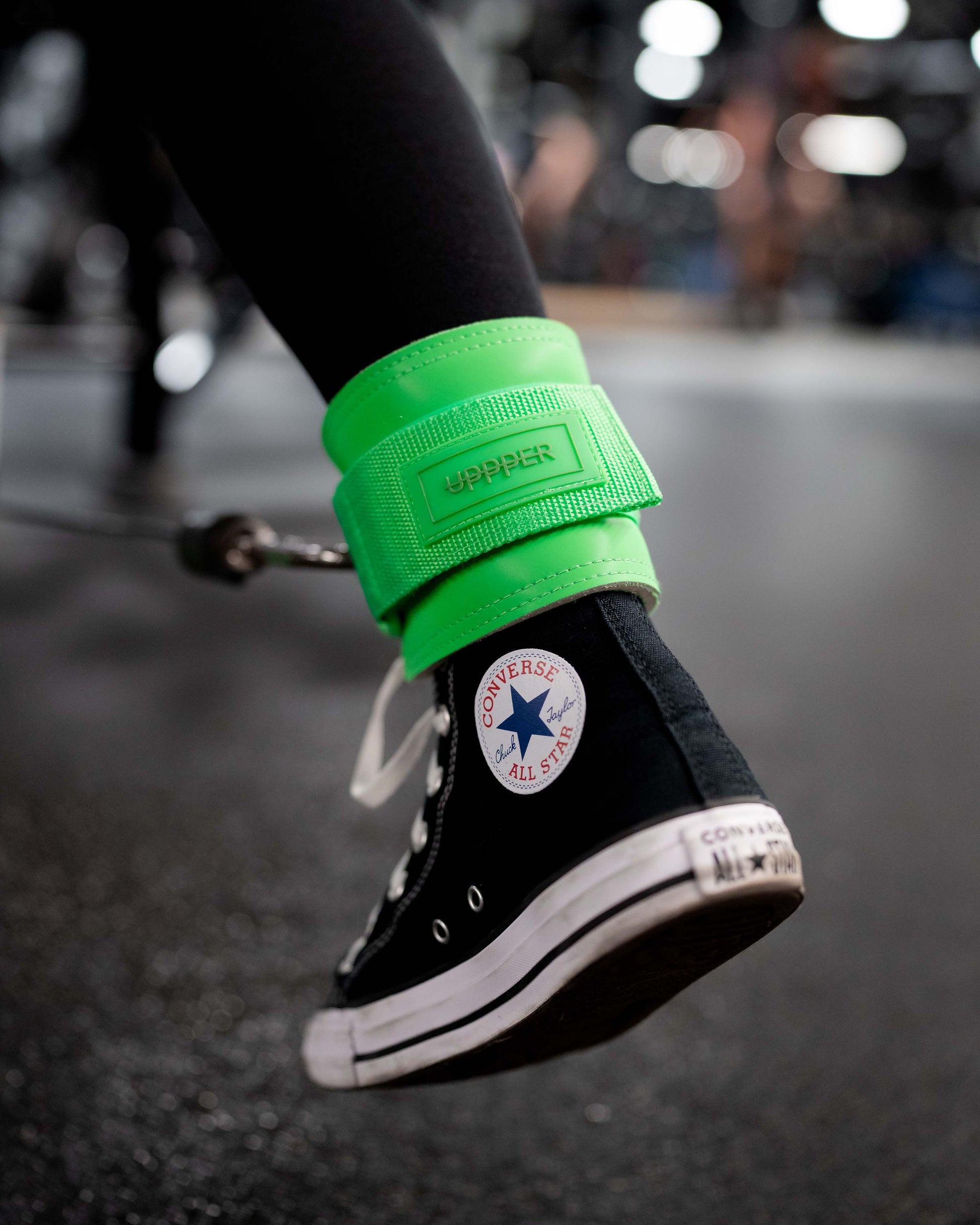 person wearing neon green ankle strap connected to cable machine
