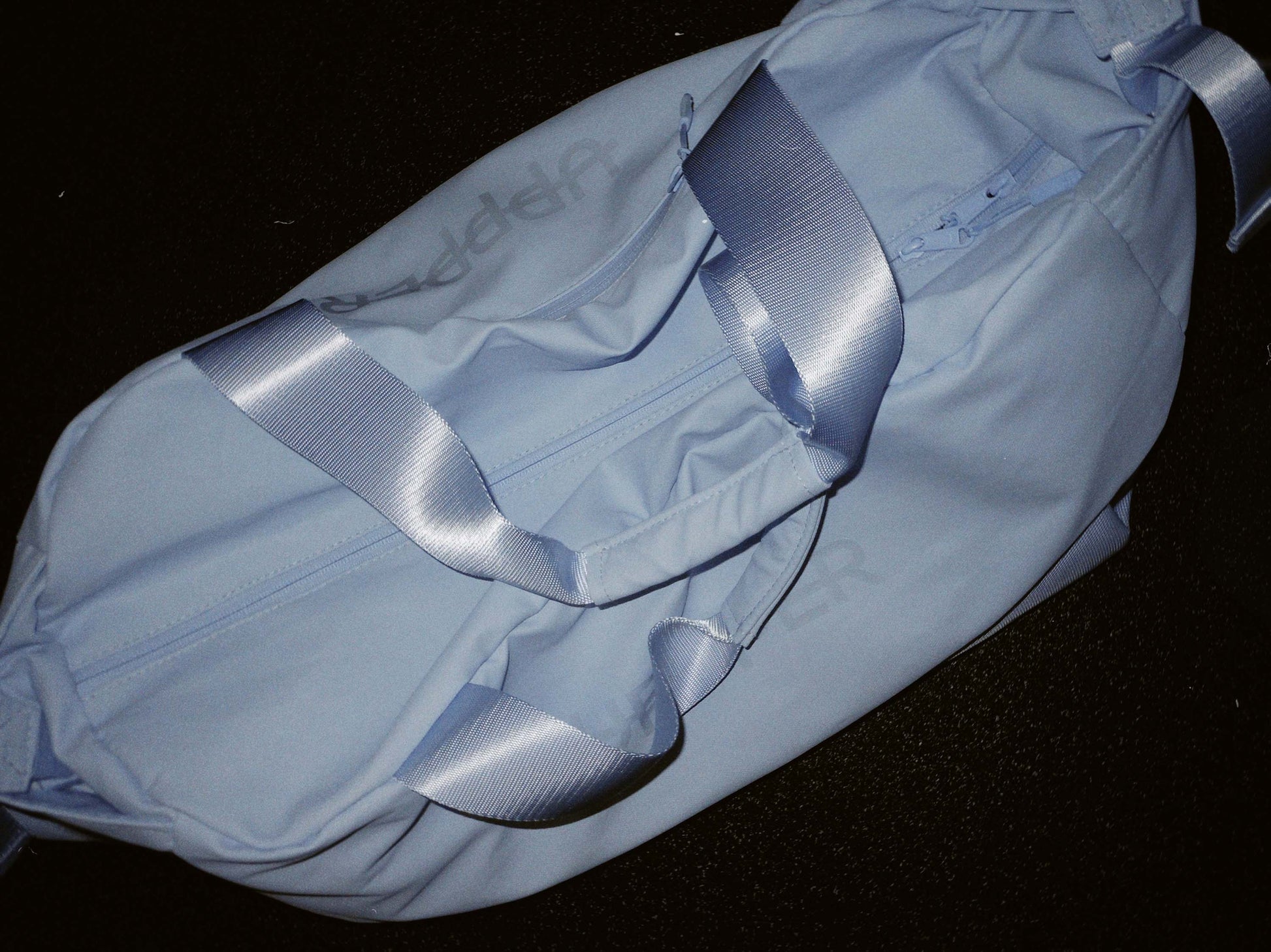 baby blue uppper gym bag on a black background