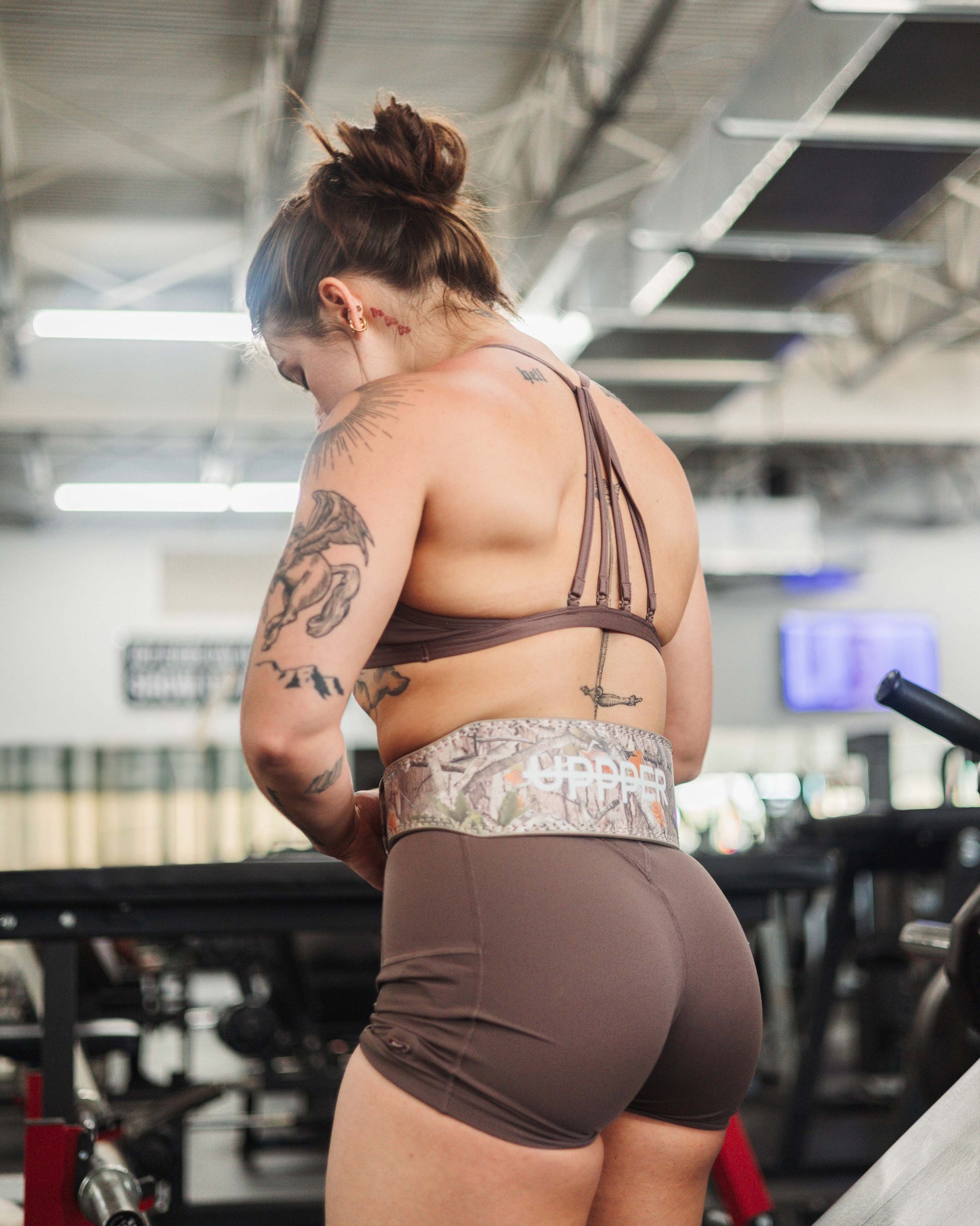 athlete in gym putting on uppper lifting with camo print 