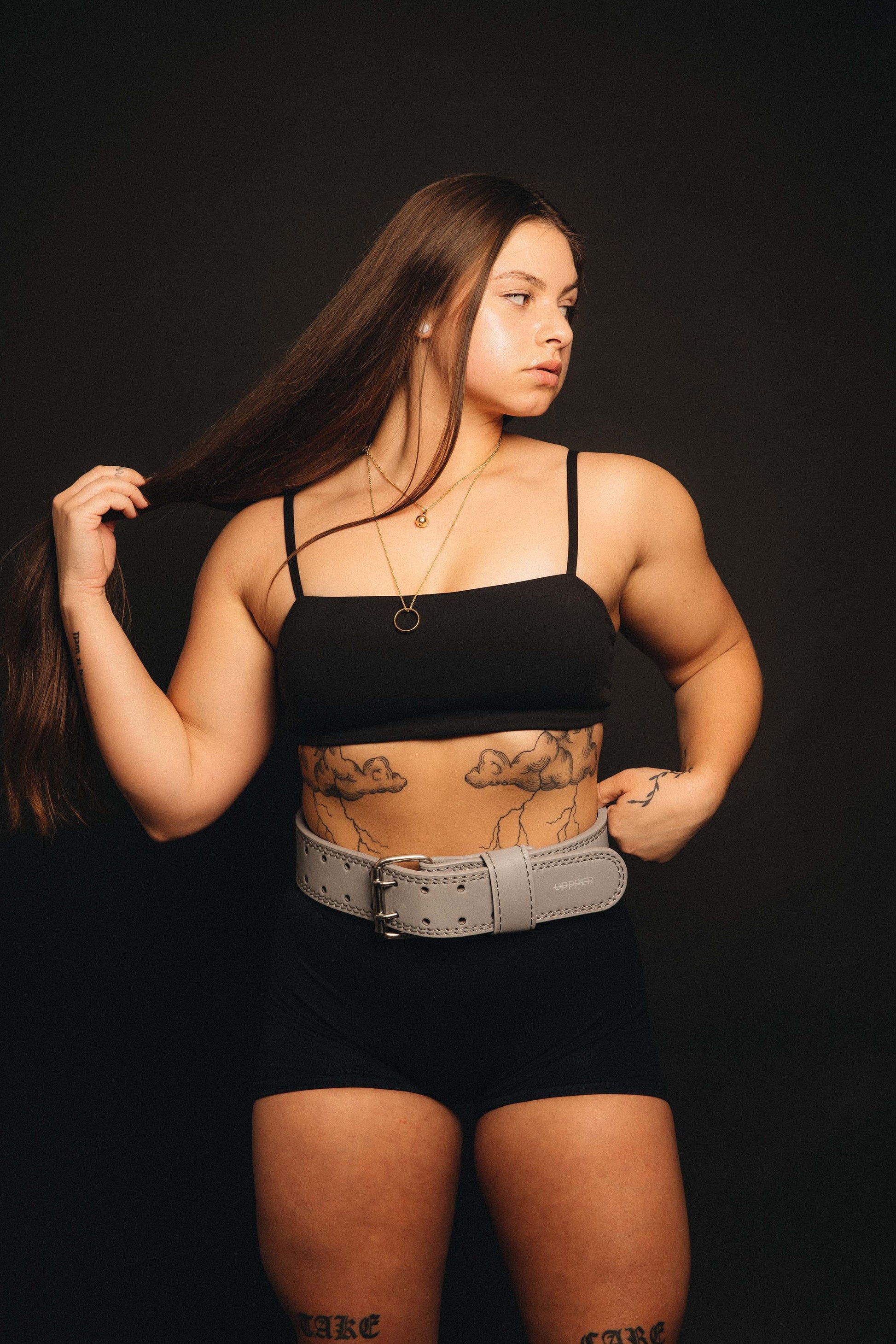 model posing in uppper reflective belt on dark background