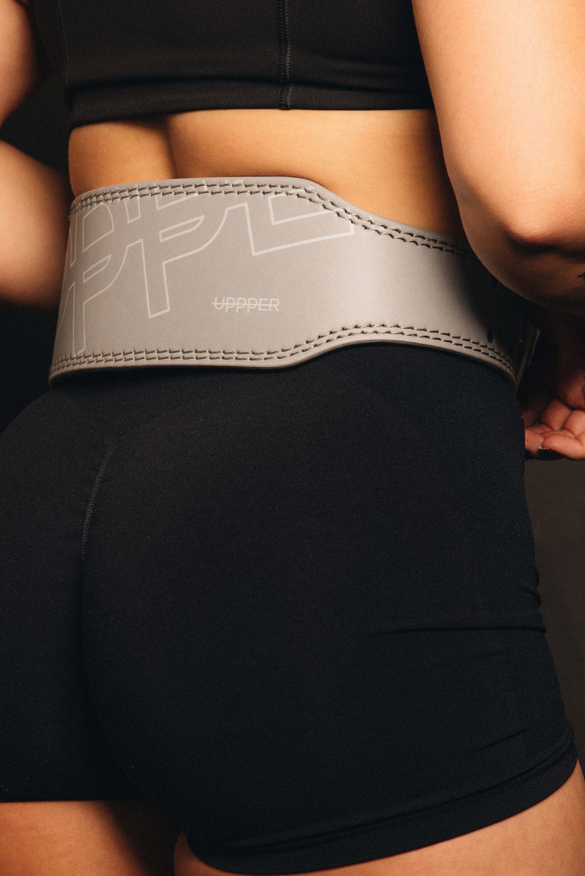 model posing in uppper reflective lifting belt back view showing logo details