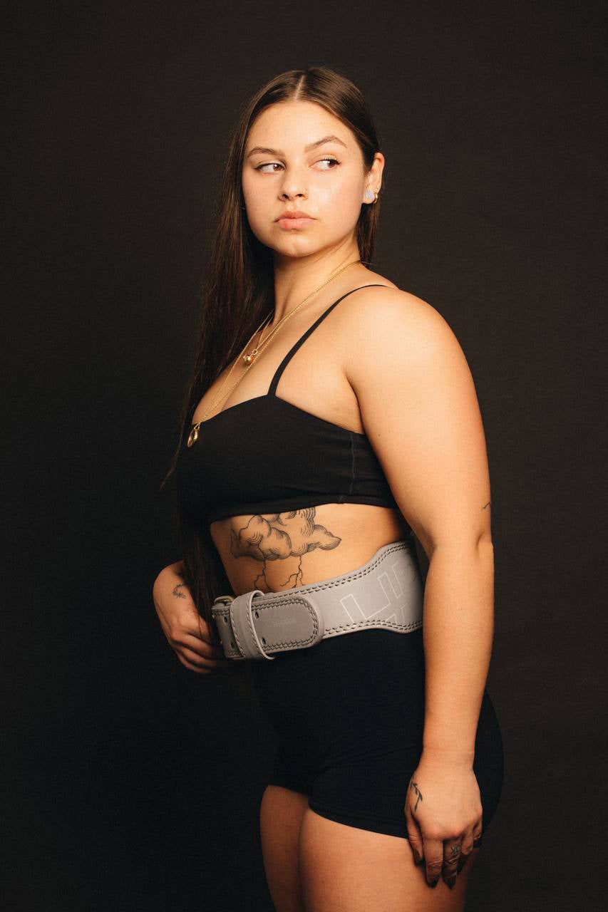 model posing in uppper reflective lifting belt side view on dark background