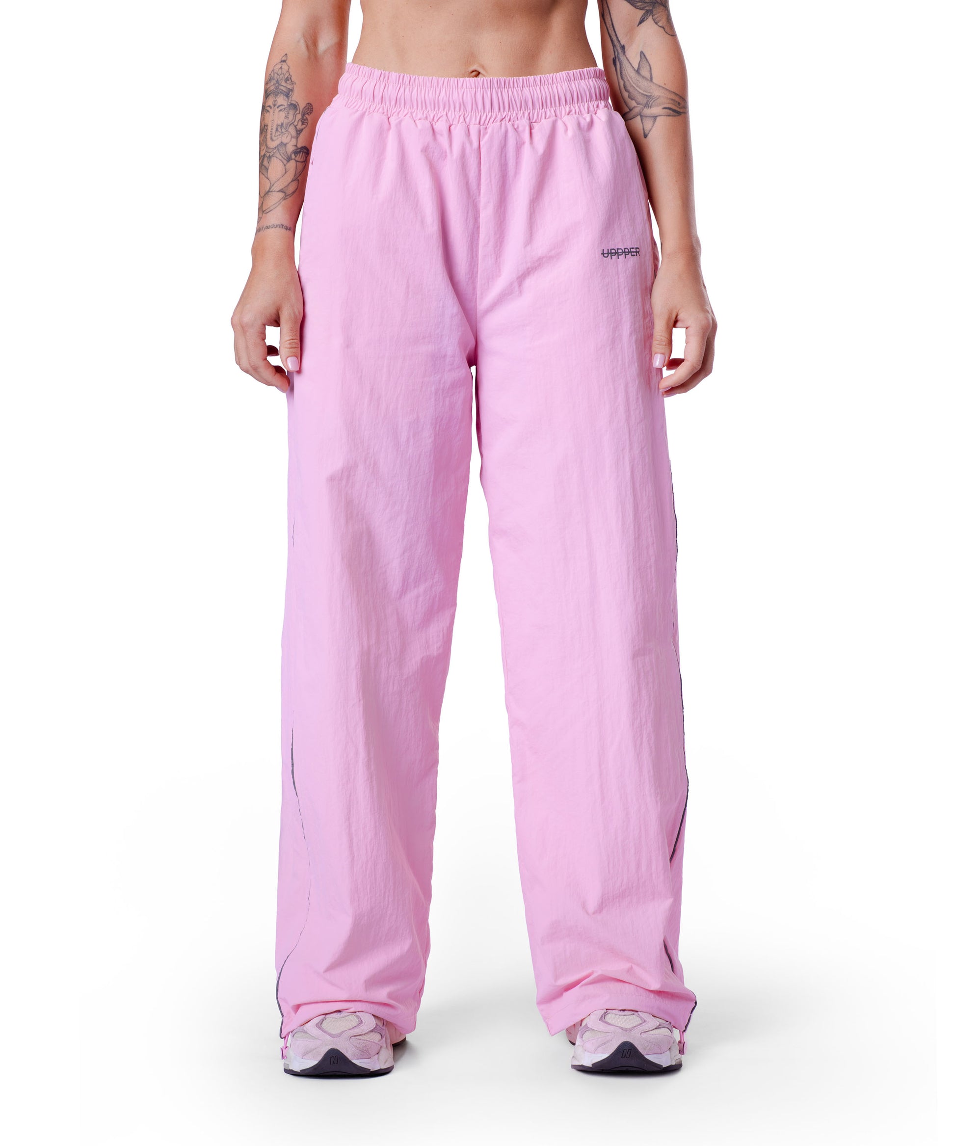front of pink uppper track pants with reflective stripe detail on white background