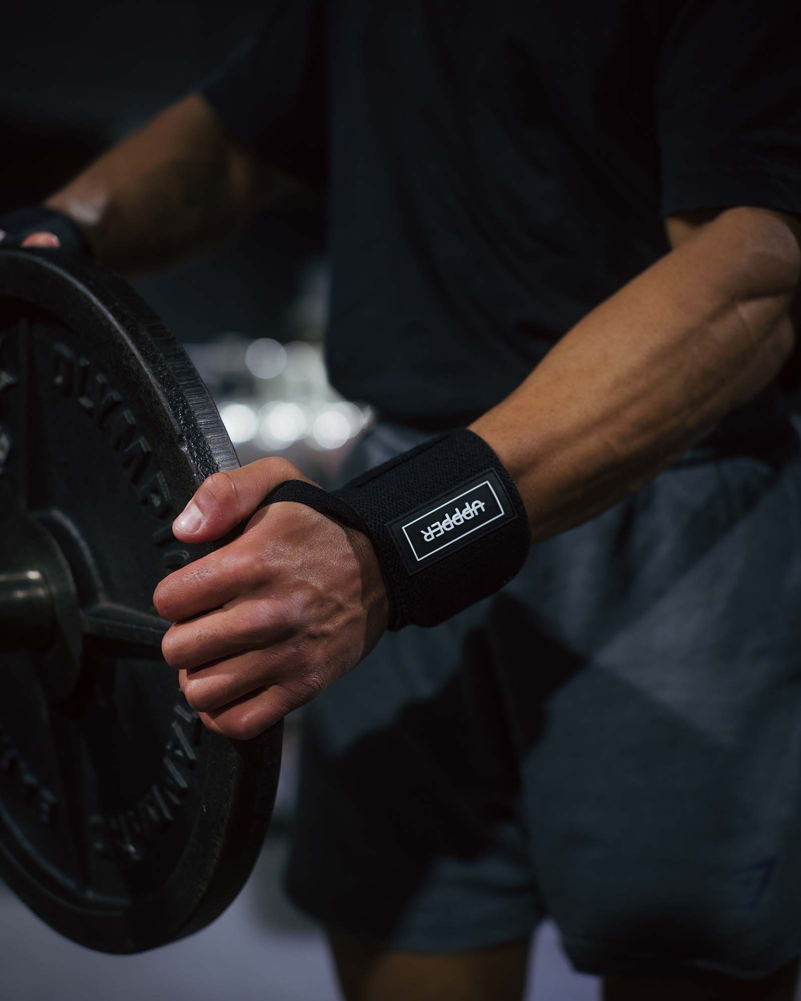 man putting on weight using uppper black wrist wraps