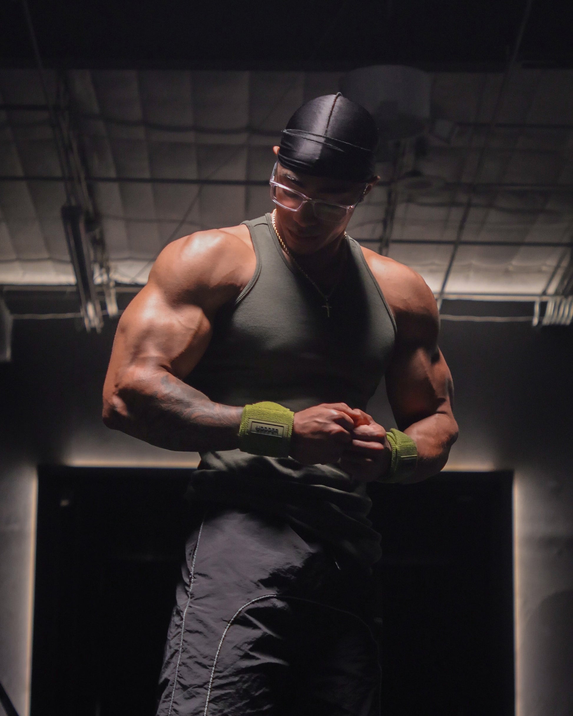 man in gym posing in kaki uppper wrist wraps